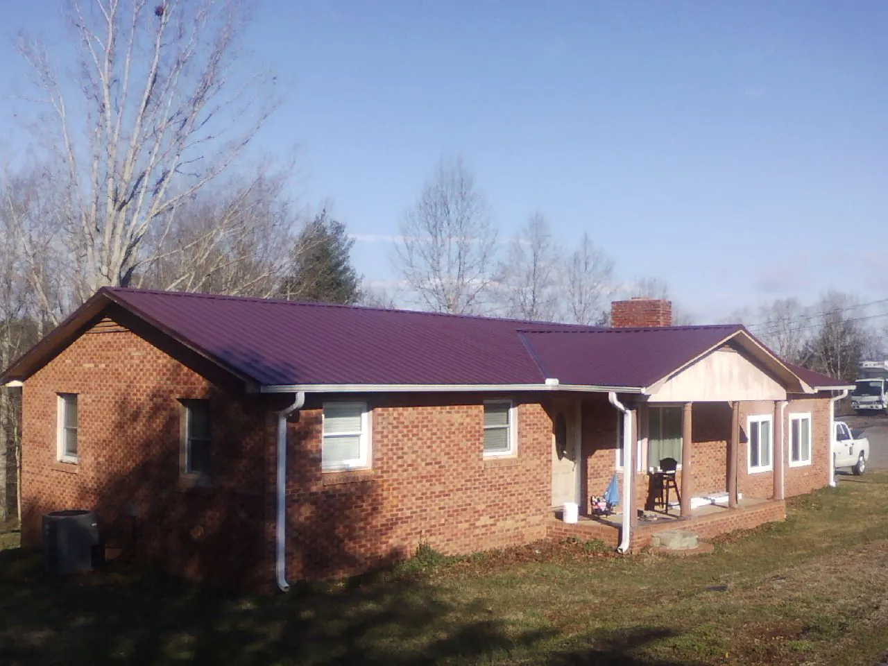 Burgundy metal roof on a brick ranch home with a new addition in Munds Park